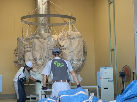 巨大なドラム式洗濯機で袋を洗う倉庫内作業