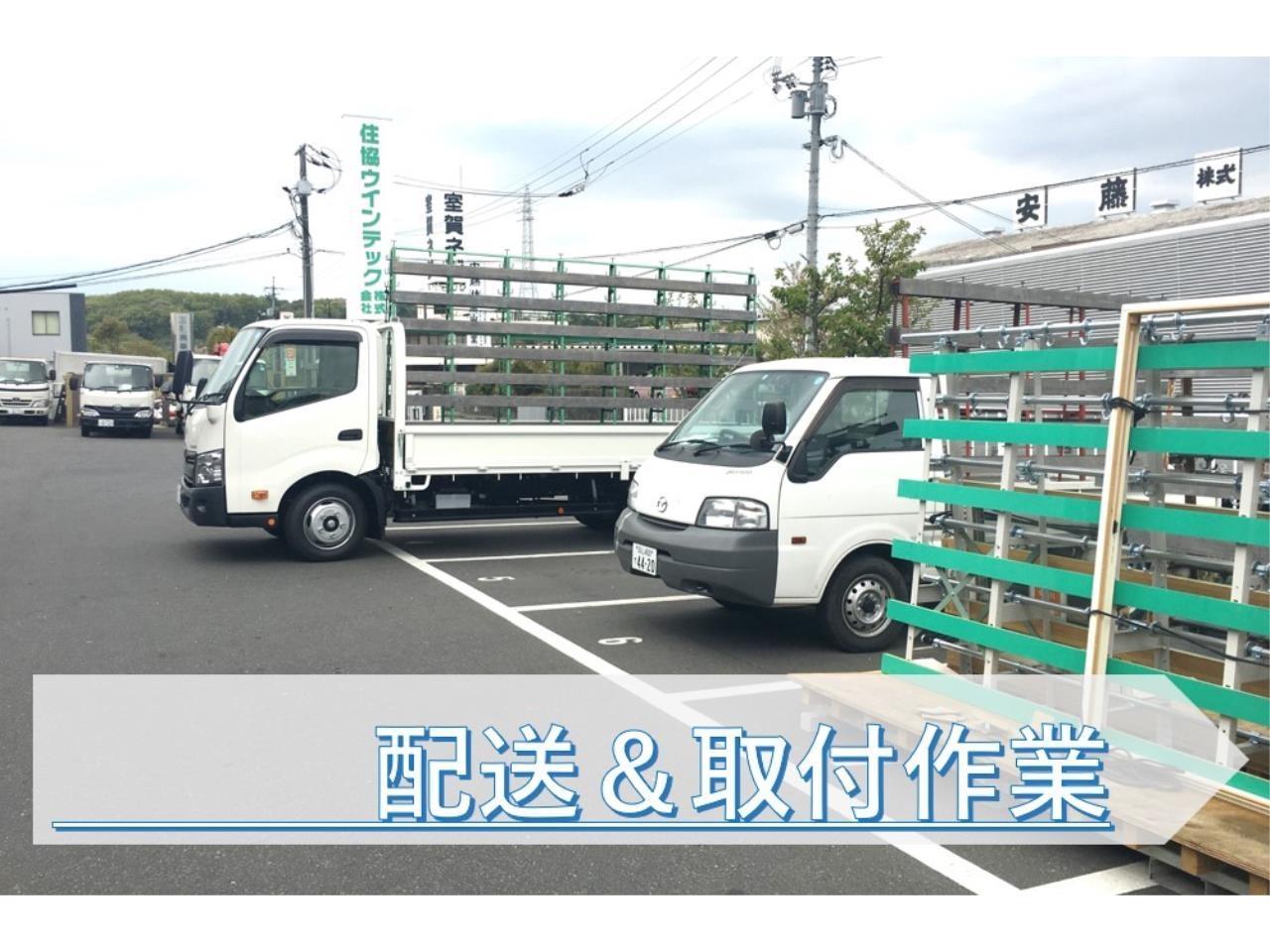 トラックでのサッシの配送やドアの組付作業