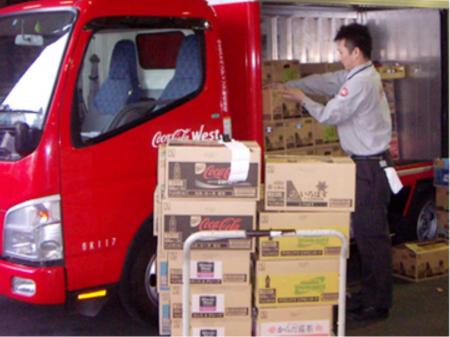 ピッキング作業スタッフ 飲料ケースを台車で運ぶ倉庫作業